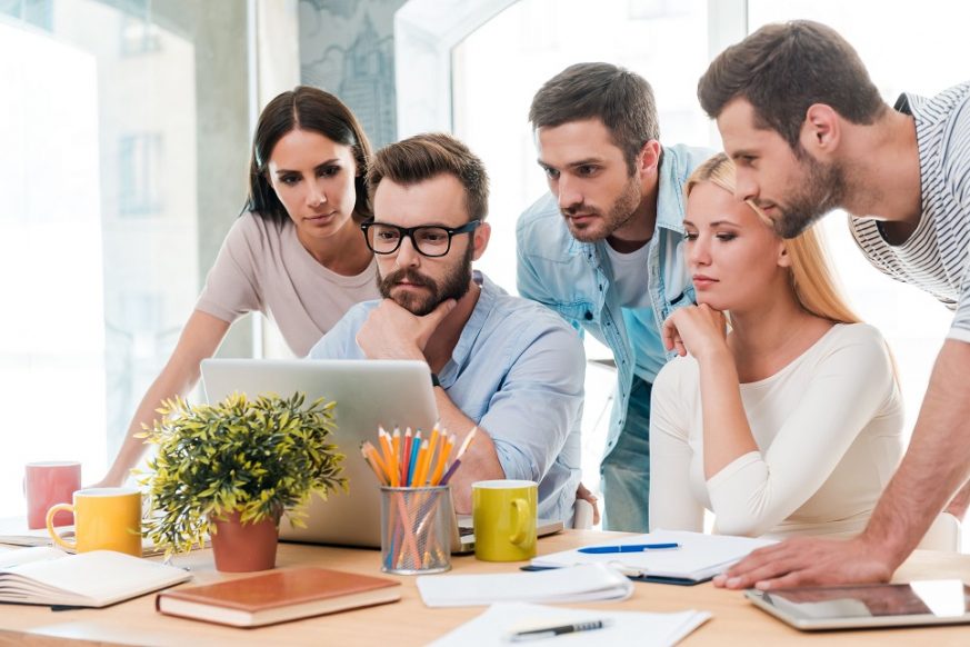 41179588 - successful business team at work. group of confident business people in smart casual wear looking at the laptop together