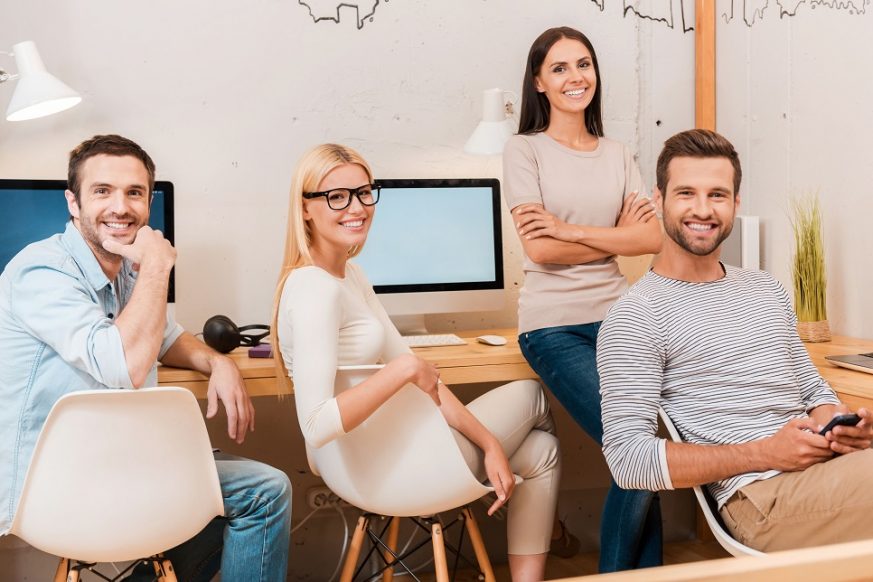 41248722 - confident business team. group of cheerful business people in smart casual wear sitting at the desk together and smiling